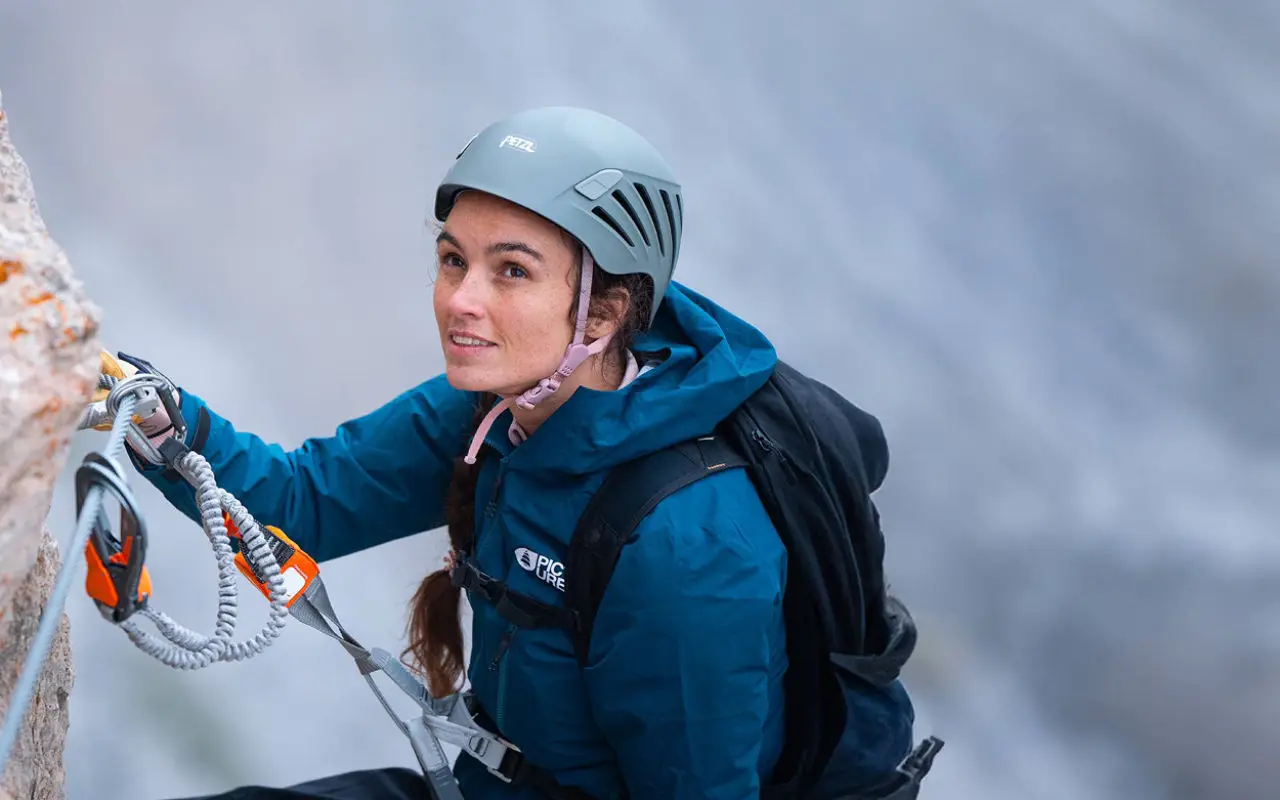 Kletterin mit Petzl-Helm und Klettersteigset am Stahlseil